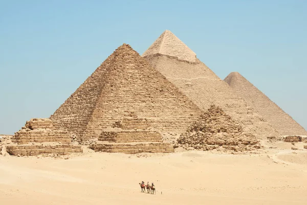 Οι τουρίστες στις καμήλες βλέπουν Khufu, Khafre, Menkaure και πυραμίδα — Φωτογραφία Αρχείου