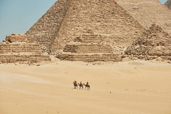 Los turistas en camellos están viendo Khufu, Khafre, Menkaure y pyrami —  Fotos de Stock