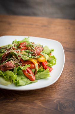 Gurme karışık salata füme ördek göğsü, vişneli domates, portakal ve çam fıstığı, narenciye soslu.