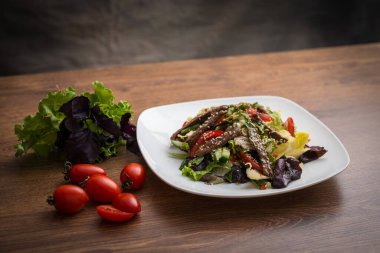 Taze salata, ızgara biftek, roka ve domates. Üst görünüm