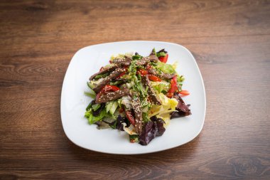 Taze salata, ızgara biftek, roka ve domates. Üst görünüm