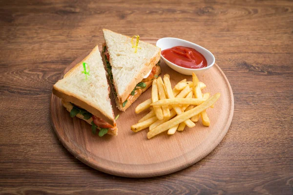 Club Sandwich Und Pommes Auf Einem Hellen Holzbrett lizenzfreie Stockfotos