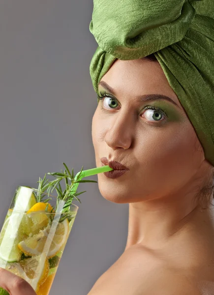 Jonge vrouw met een drankje van citroen en limoen — Stockfoto