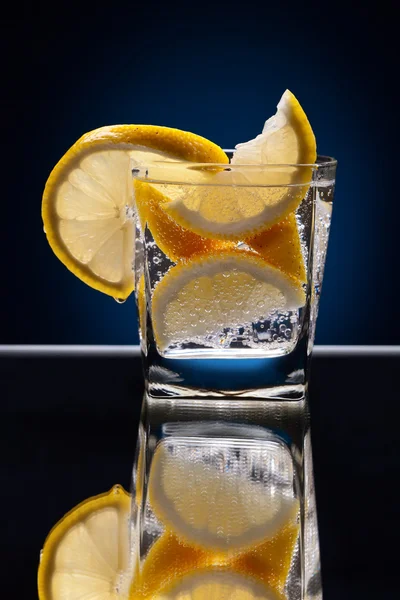 Glass of alcoholic drink with lemon — Stock Photo, Image