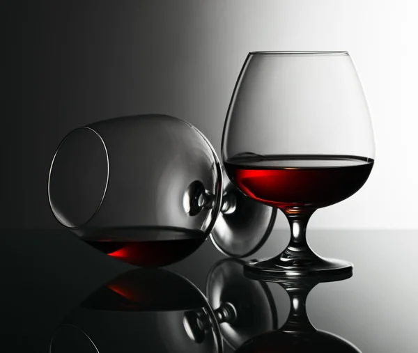 Two snifters of brandy on glass table — Stock Photo, Image