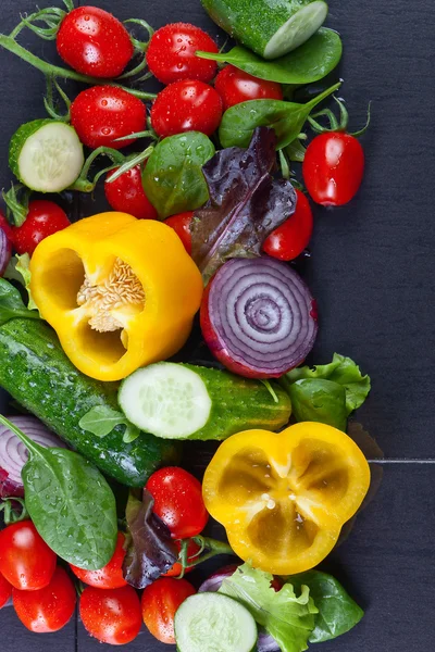 Šťavnaté zralé zelenina s rukolou a špenátem na černý stůl — Stock fotografie
