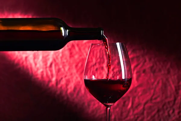 Üveg és üveg vörös bort a sötét háttér — Stock Fotó