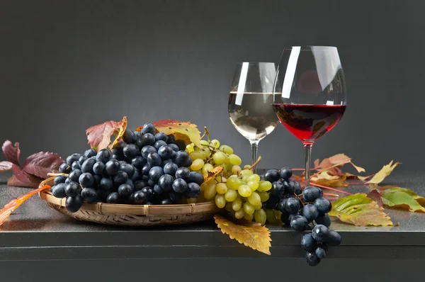 Uvas azuis e brancas com copos de vinho — Fotografia de Stock