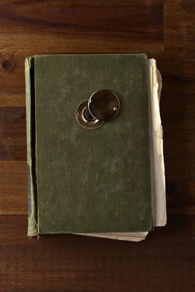 Stará kniha s kukátko na dřevěný stůl — Stock fotografie