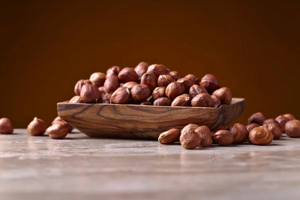 Hazelnuts in old wooden dish — Stock Photo, Image