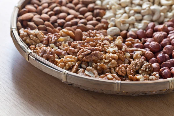 Different nuts in old wooden dish — Stock Photo, Image