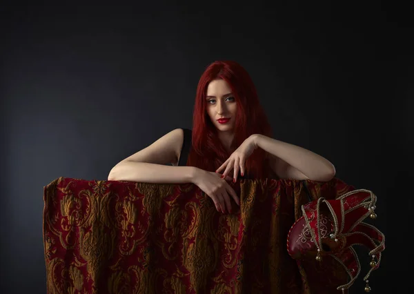 Beautiful redheaded woman with carnival mask on black background — Stock Photo, Image