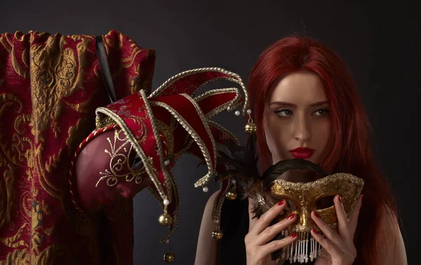 Mulher ruiva bonita com máscaras de carnaval em backgroun preto — Fotografia de Stock