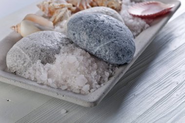Taşlar ve kabukları eski ahşap bir masa üzerinde deniz tuzu 