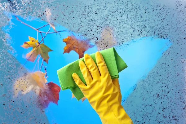 在清洗窗户的黄色橡胶手套的手 — 图库照片