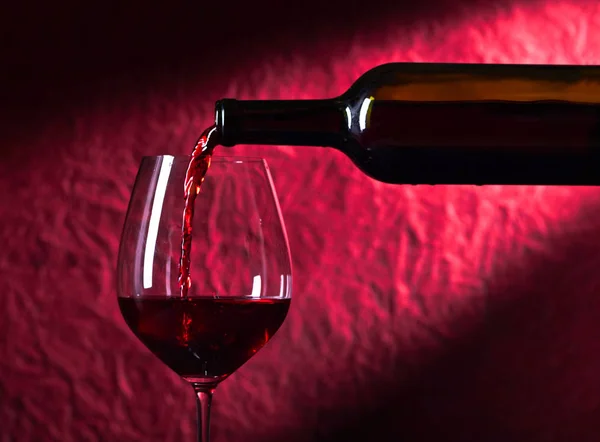 Bottle and glass of red wine on a dark  background — Stock Photo, Image