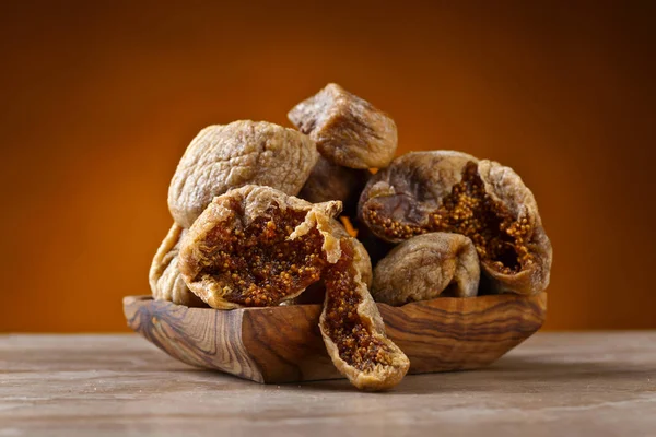 Dried figs in wooden dish on ceramic table — Stock Photo, Image
