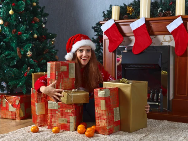 Ung kvinna med gåvor i rummet med juldekorationer — Stockfoto