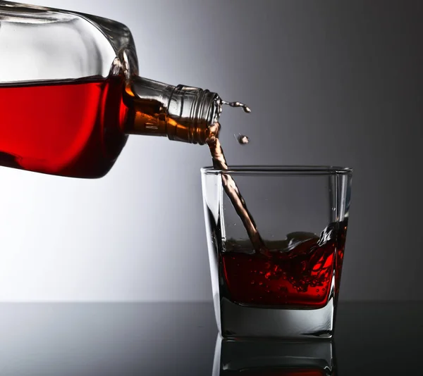 Bottiglia e bicchiere di whisky su un tavolo di vetro — Foto Stock