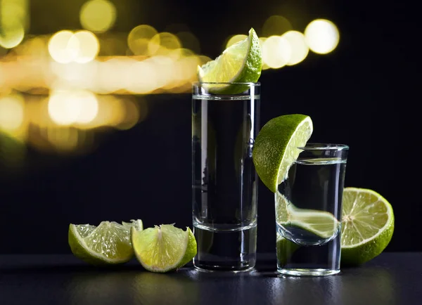 Guld tequila och lime på svart bord — Stockfoto