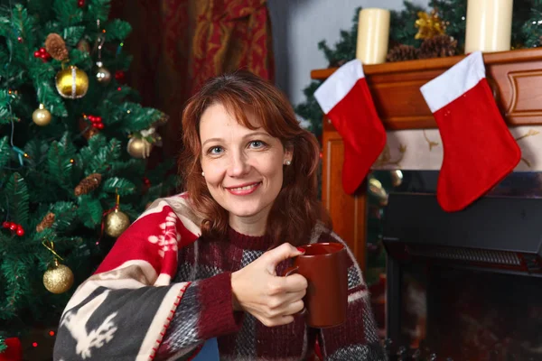 クリスマスの装飾と暖炉が付いている部屋の女性 — ストック写真