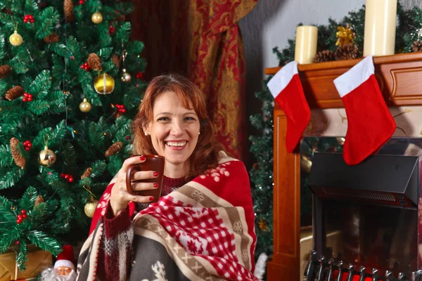クリスマスの装飾と暖炉が付いている部屋の女性 — ストック写真