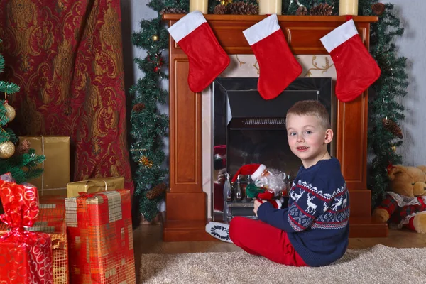 Jongen met speelgoed op het tapijt in de kamer met Kerstmis decoratio — Stockfoto