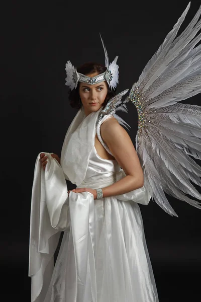 Beautiful young model wearing a white dress with angel wings in — Stock Photo, Image