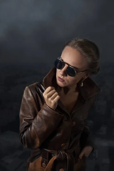 Портрет красивої жінки в коричневому шкіряному пальто і сонцезахисних окулярах — стокове фото