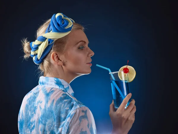 Beautiful woman with cocktail on a blue background — Stock Photo, Image