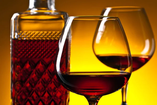 Glasses of brandy on  on a yellow background — Stock Photo, Image