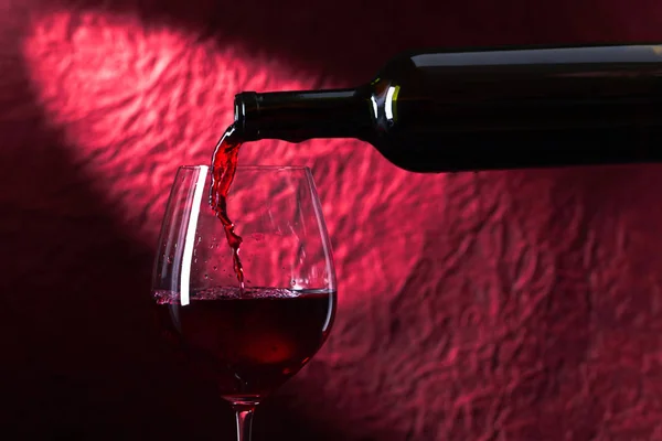 ボトルと暗い背景に赤ワインのガラス — ストック写真
