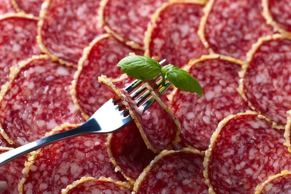 Salami sausage slices and green basil — Stock Photo, Image