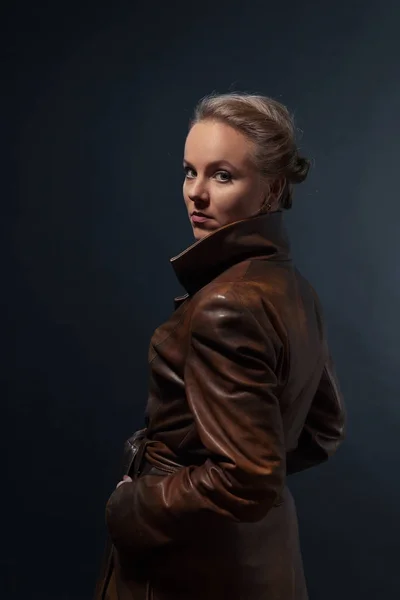 Portrait of young beautiful woman in brown leather coat — Stock Photo, Image