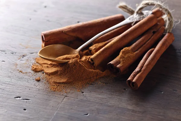 Cinnamon sticks and powder on a wooden table — Stock Photo, Image