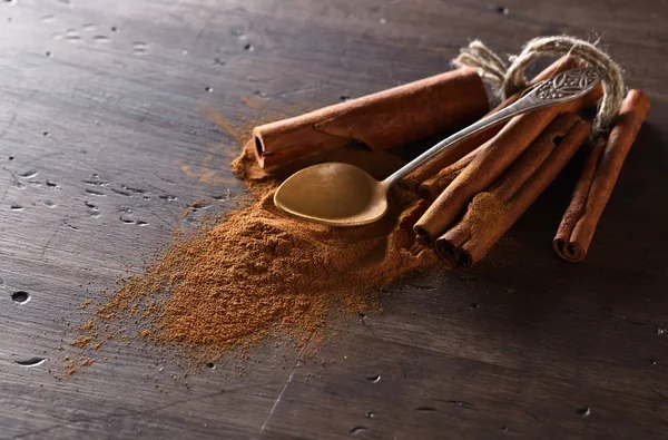 Cinnamon sticks and powder on a wooden table — Stock Photo, Image