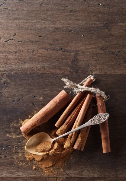 Varas de canela e pó em uma mesa de madeira — Fotografia de Stock