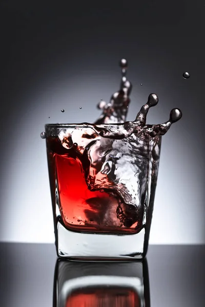 Glass of whiskey with falling ice on a black background — Stock Photo, Image