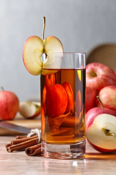 Glas äppeljuice och mogna rosa äpplen på ett köksbord — Stockfoto