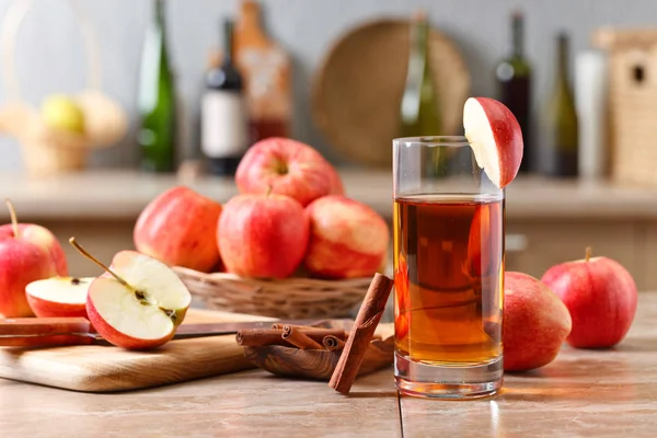 Glas äppeljuice och mogna rosa äpplen på ett köksbord — Stockfoto