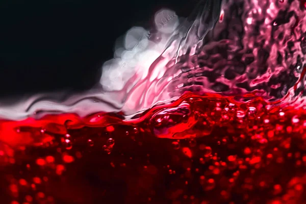 Salpicaduras abstractas de vino tinto sobre un fondo negro — Foto de Stock