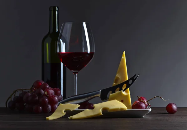 Сыр и красное вино на старом деревянном столе — стоковое фото