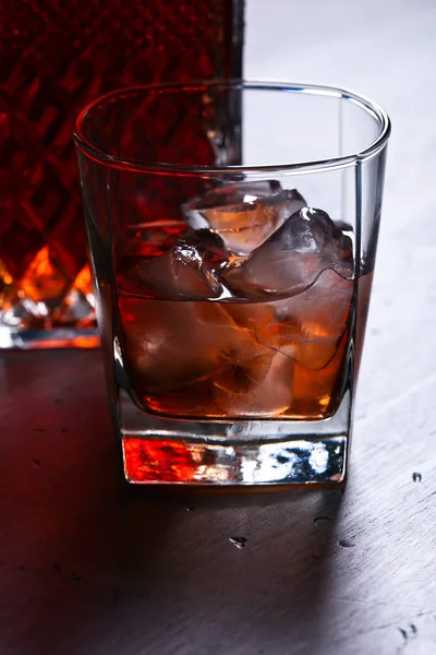 Glass of whiskey with natural ice on a wooden table — Stock Photo, Image