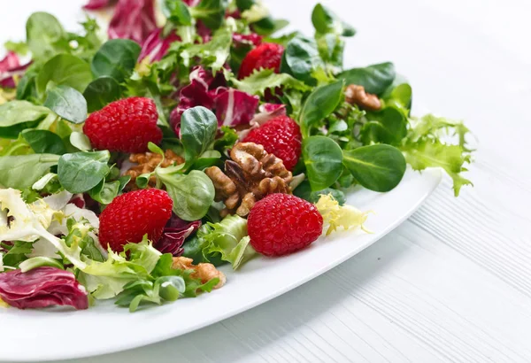 Green vegan salad with raspberry and nuts — Stock Photo, Image