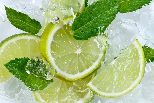 Lime slices and mint leaves on ice — Stock Photo, Image