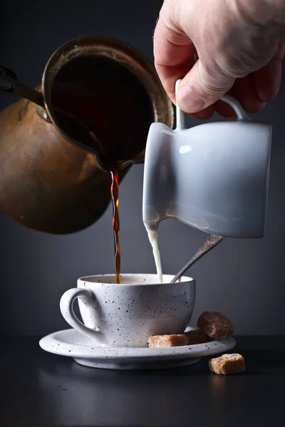 Xícara de café com leite e açúcar mascavo no fundo escuro — Fotografia de Stock