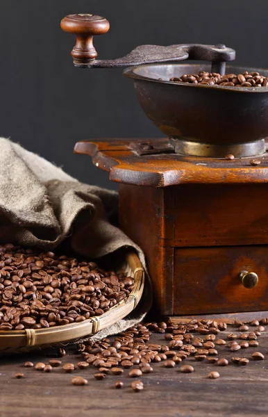 Стара кавомолка і смажені кавові зерна на дерев'яному столі — стокове фото