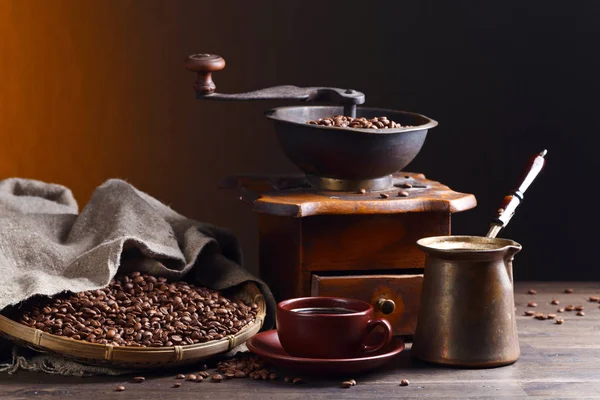 Taza de café negro, molinillo de café y frijoles asados — Foto de Stock