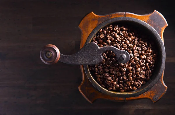 Primer plano de molinillo de café viejo y granos de café tostados — Foto de Stock