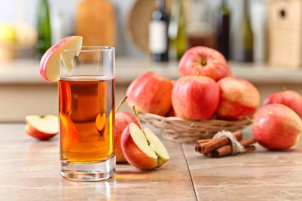 Glas äppeljuice och mogna rosa äpplen på ett köksbord — Stockfoto